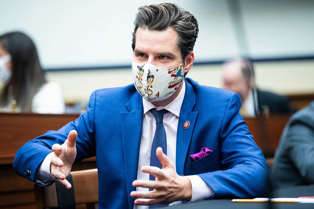 U.S. Congressman Matt Gaetz in a cobalt blue suit and tie with a purple pocket handkerchief accented by dramatic anchor-themed face mask.